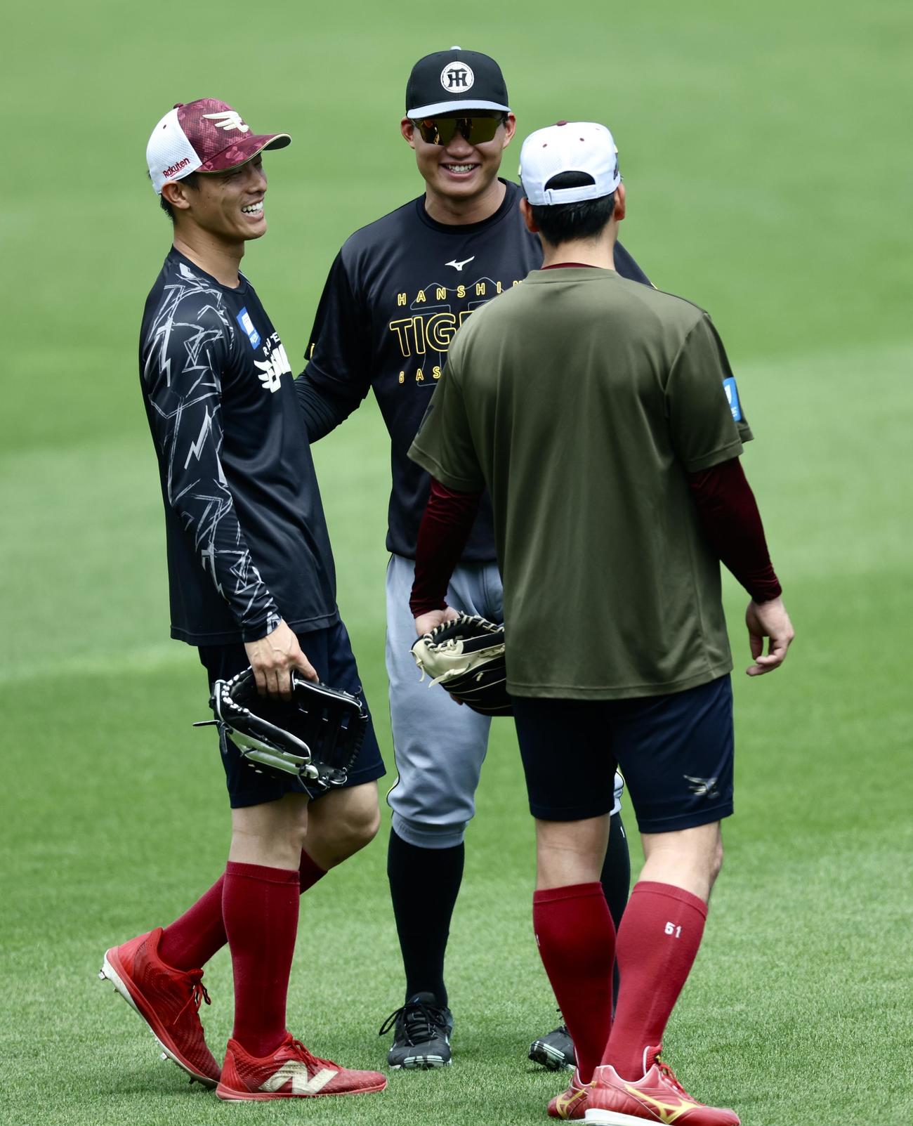 楽天対阪神　試合前、楽天辰己（左）小郷（右）と言葉を交わす阪神森下（撮影・河田真司）