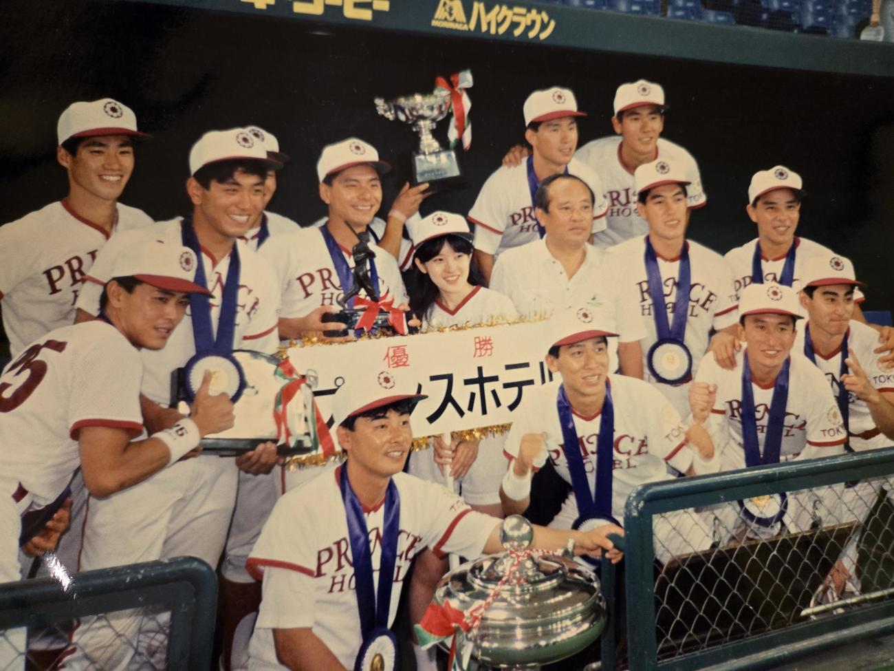 プリンスホテルの選手と写真に収まる奥田裕一郎氏（中央＝提供写真）