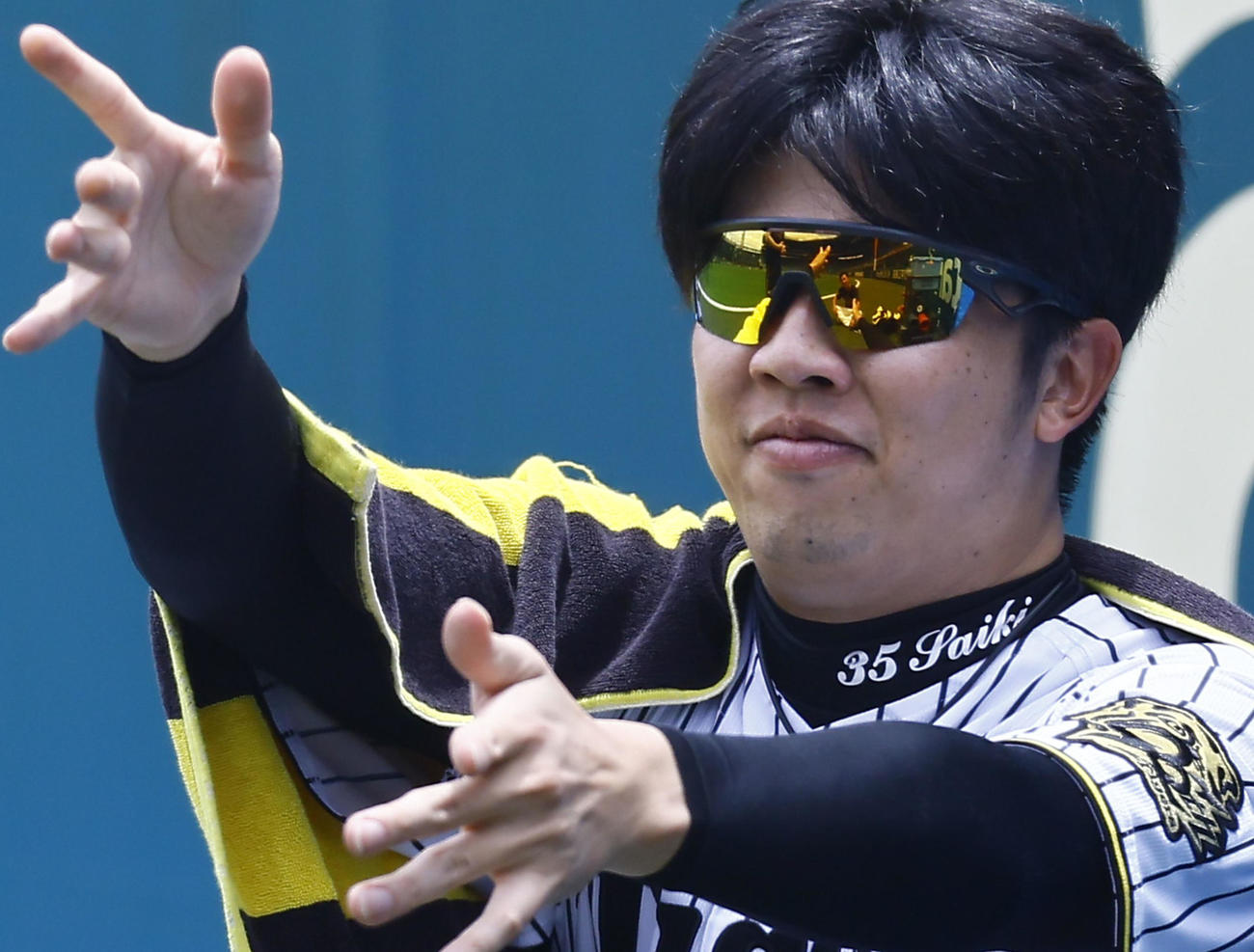 ランニングを終えた伊藤将（左）を、手をひらひらさせながらねぎらう阪神才木（撮影・藤尾明華）