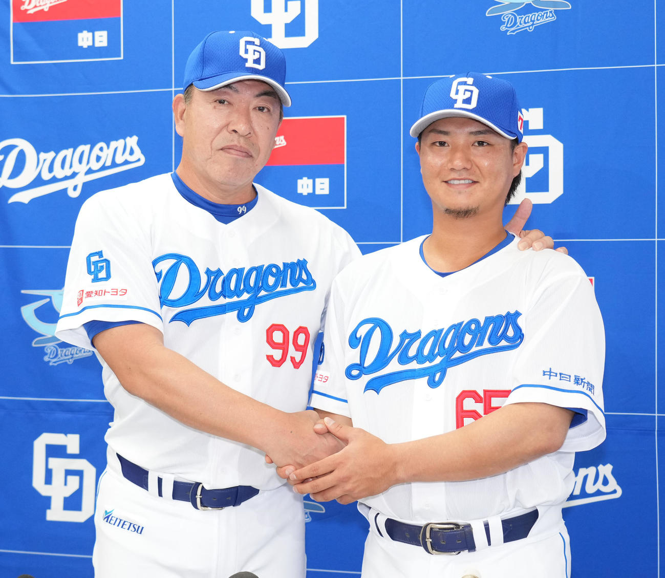 入団会見後、井上監督（左）と握手を交わしポーズを決める佐藤（撮影・森本幸一）