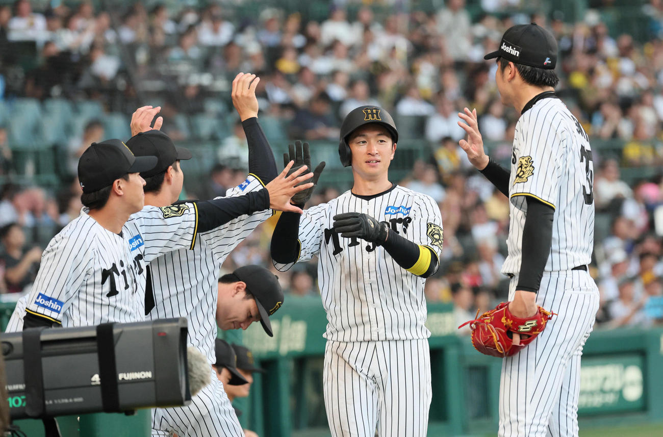 阪神対ロッテ　3回裏阪神2死二塁、近本は中野の中前先制適時打で生還し、才木（右）らに迎えられる（撮影・宮崎幸一）