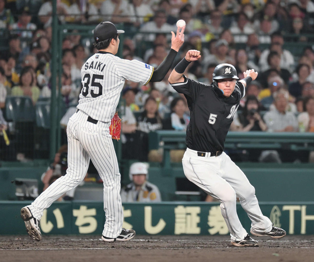 阪神対ロッテ　7回表ロッテ2死二、三塁、才木は高部の打球を右手に受けながらも、三本間で安田を挟殺する（撮影・宮崎幸一）