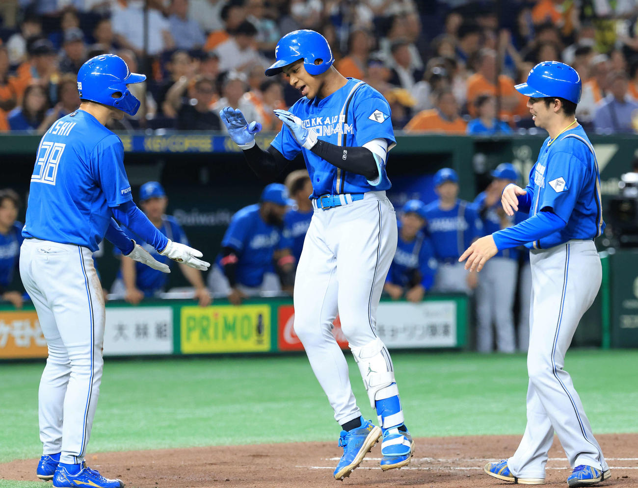 巨人対日本ハム　2回表日本ハム無死一塁、万波（中央）は2点本塁打を放ちハイタッチで生還（撮影・浅見桂子）
