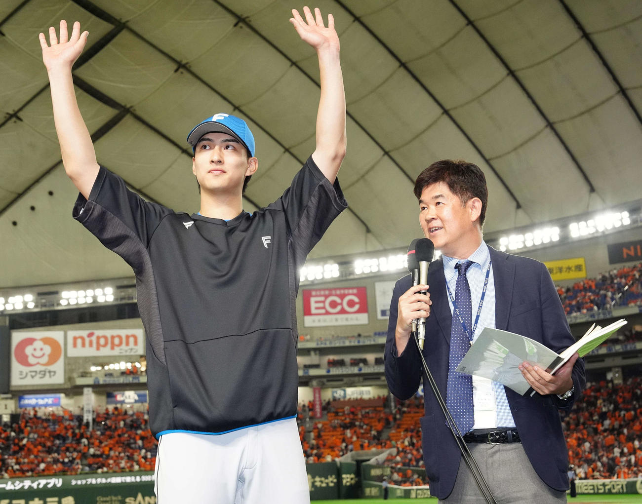 巨人対日本ハム　試合後、インタビューを受ける日本ハム達（左）。右はNHK宮田アナウンサー（撮影・江口和貴）