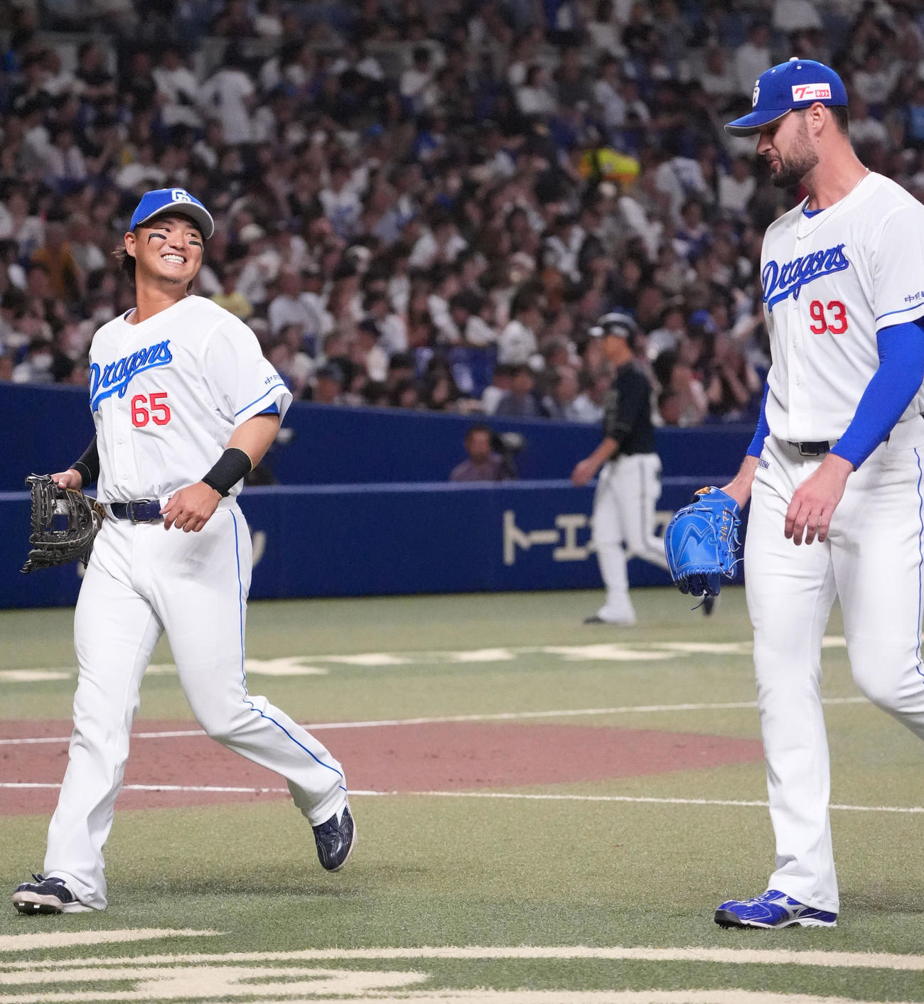 中日対オリックス　2回表終了、マラー（右）に明るい表情で声をかけベンチへ戻る佐藤（撮影・森本幸一）
