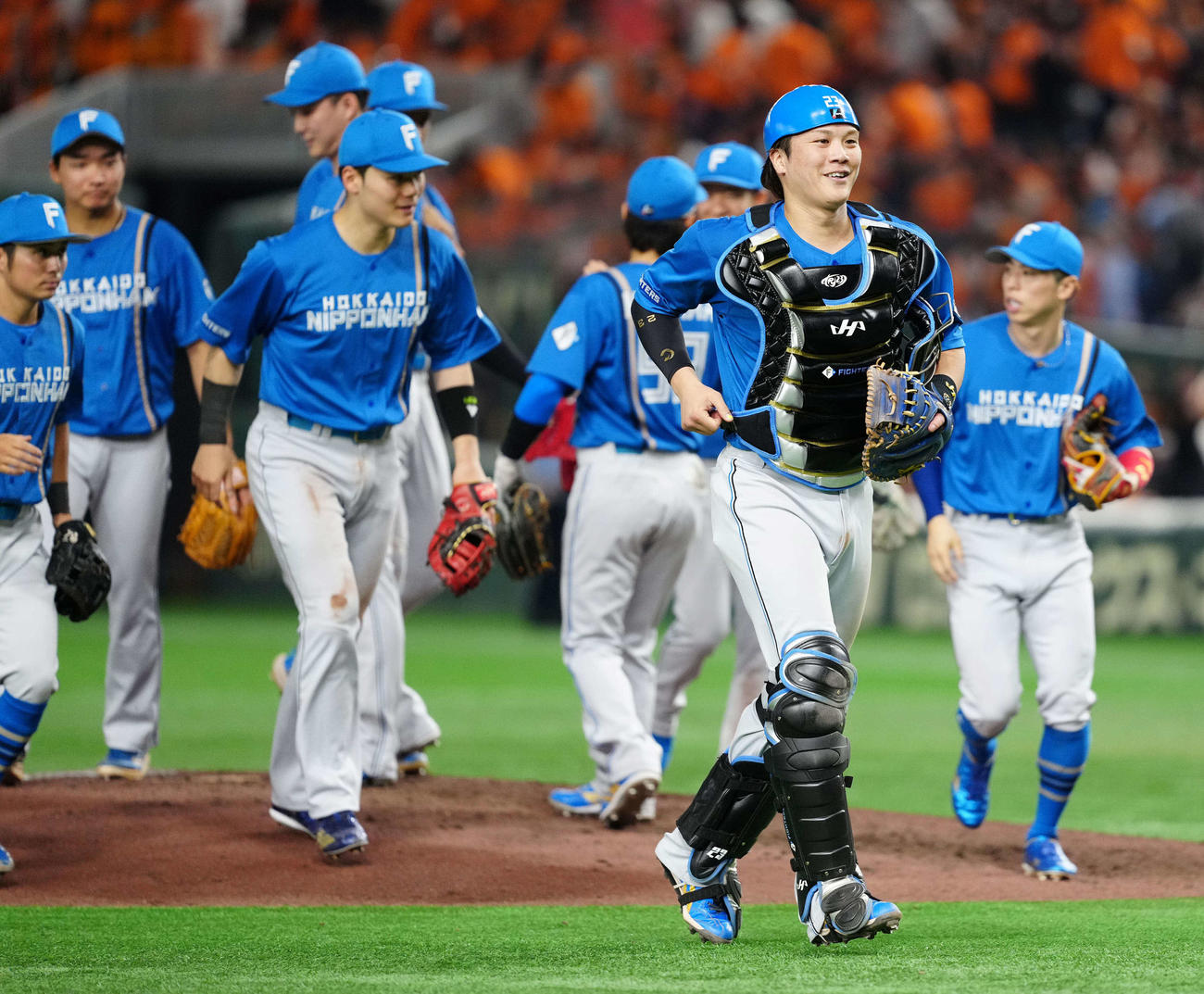 巨人対日本ハム　巨人に勝利し笑顔で引き揚げる日本ハム捕手伏見（手前）（撮影・江口和貴）
