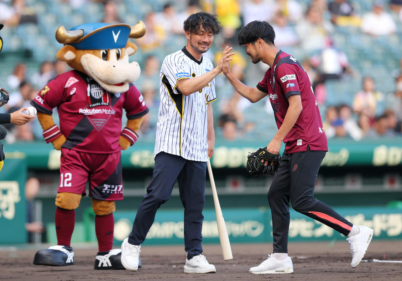 阪神対ロッテ　ファーストピッチを終えた神戸岩波（右）は打席に立った阪神OB狩野とタッチをかわす（撮影・上山淳一）