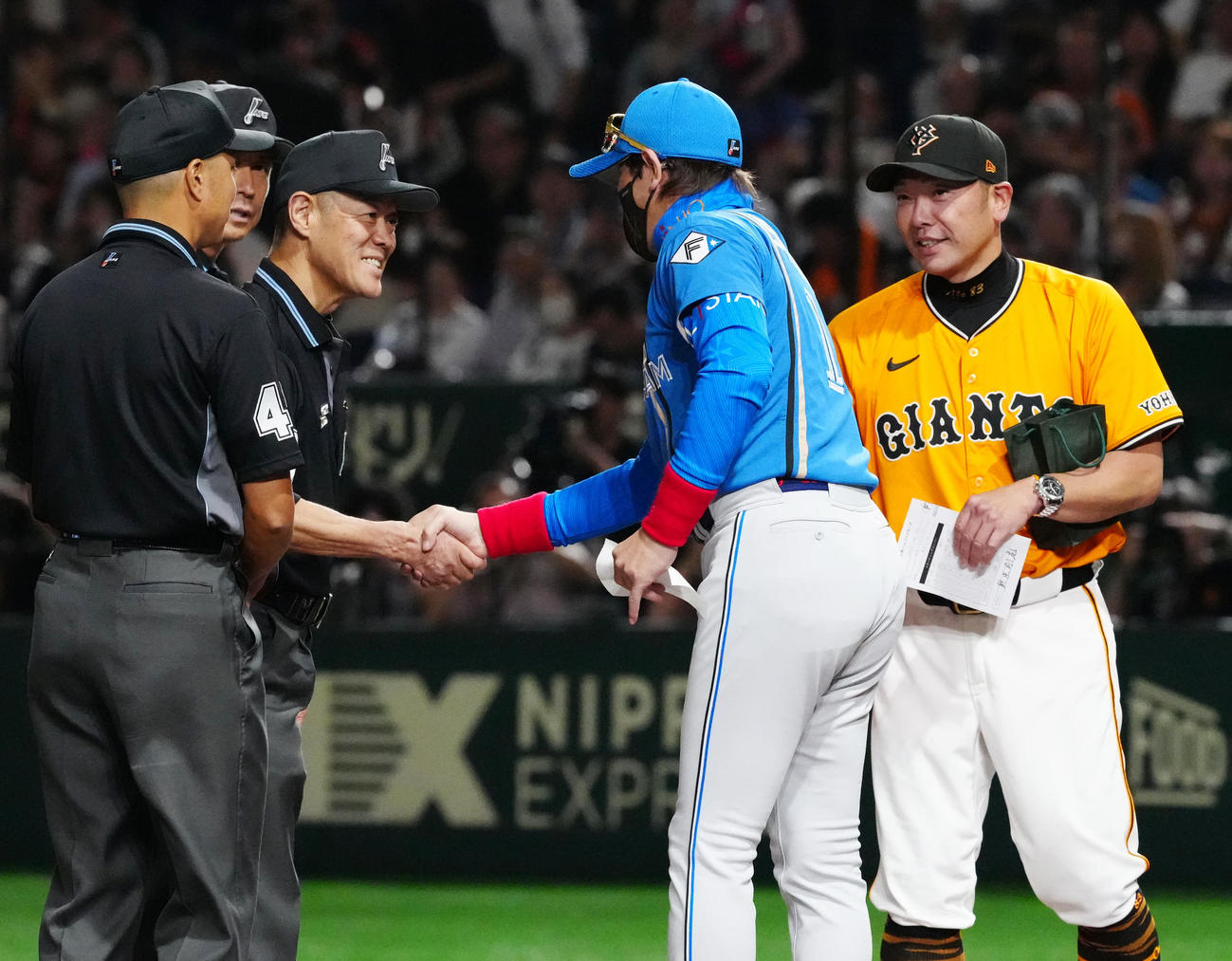 巨人対日本ハム　試合前、メンバー表の最終確認で巨人阿部監督（右）にプレゼントを渡した日本ハム新庄監督（撮影・江口和貴）