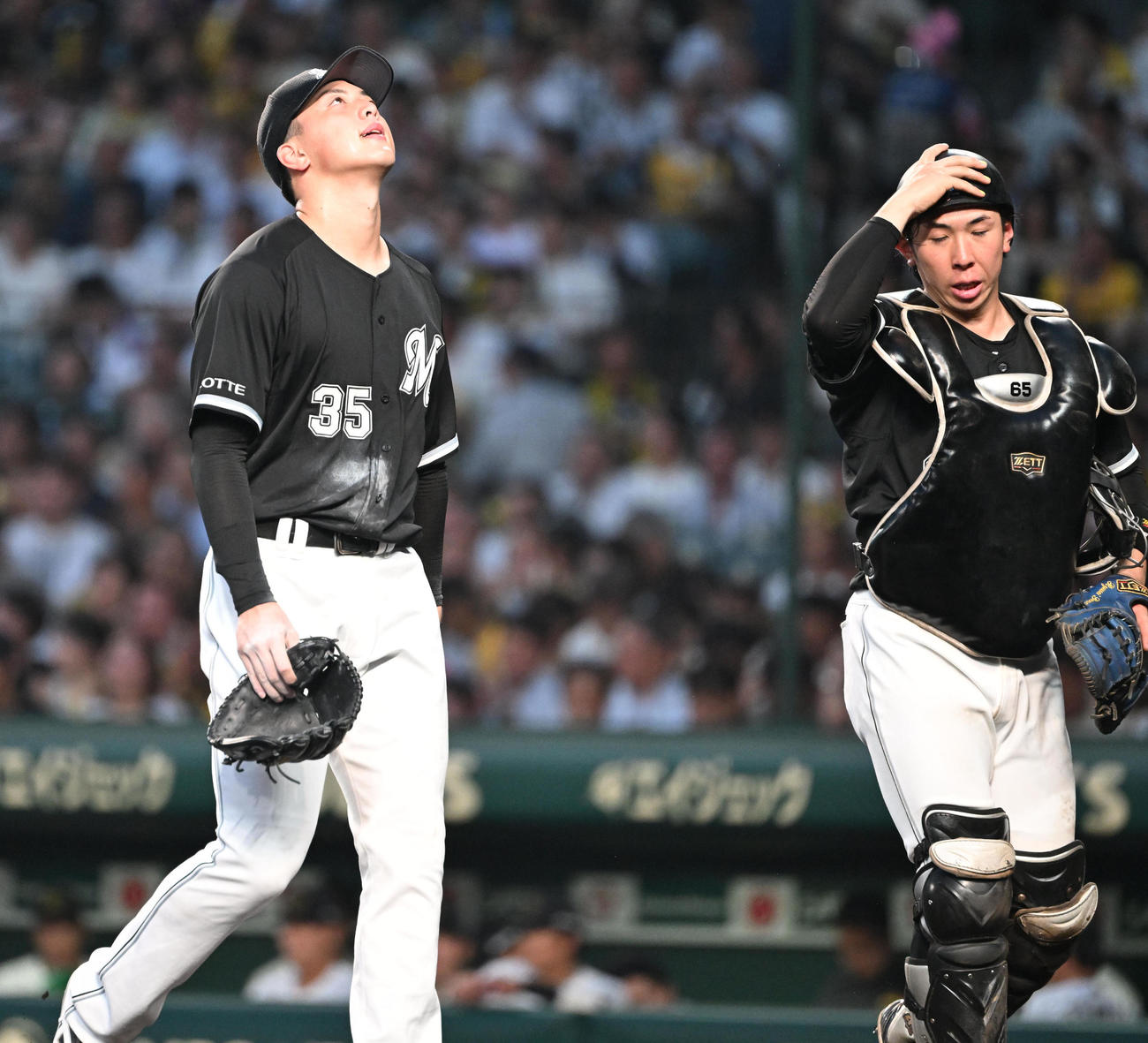 阪神対ロッテ　3回に先制を許し悔しそうにベンチに引き揚げるロッテ田中晴（左）（撮影・和賀正仁）