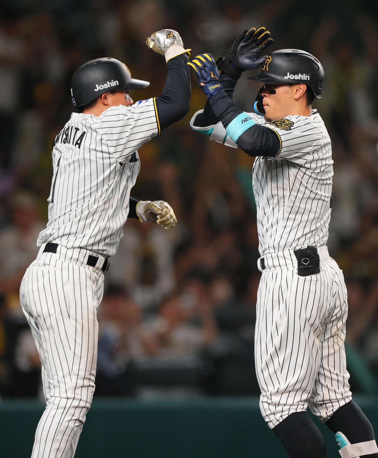 阪神対ロッテ　8回裏阪神2死二塁、佐藤輝（右）は中越え2点本塁打を放ち森下とタッチをかわす（撮影・上山淳一）