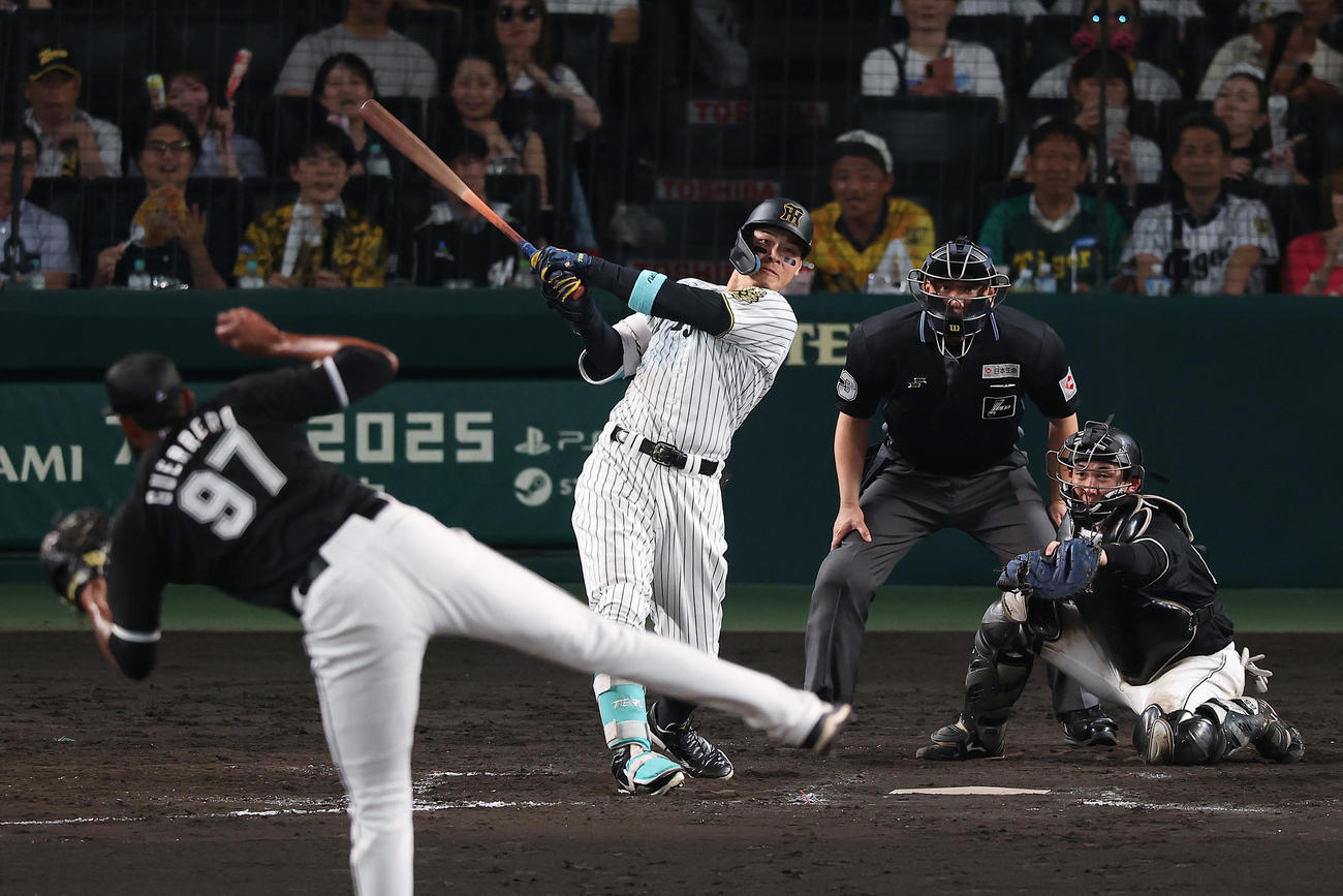 阪神対ロッテ　8回裏阪神2死二塁、中越え2点本塁打を放つ佐藤輝。投手ゲレーロ（撮影・前田充）