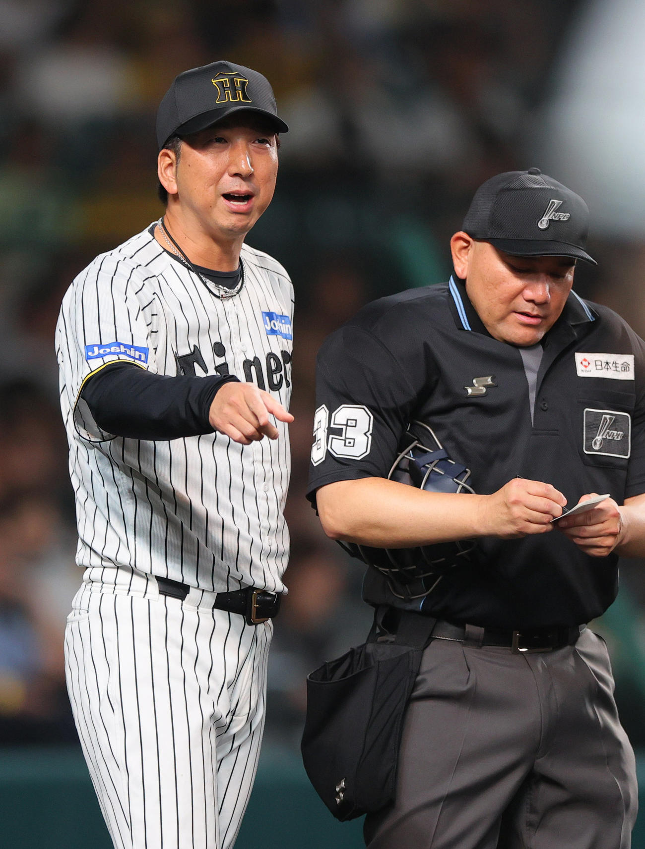 阪神対ロッテ　7回を終え、阪神藤川監督（右）は球審に交代を告げる（撮影・上山淳一）
