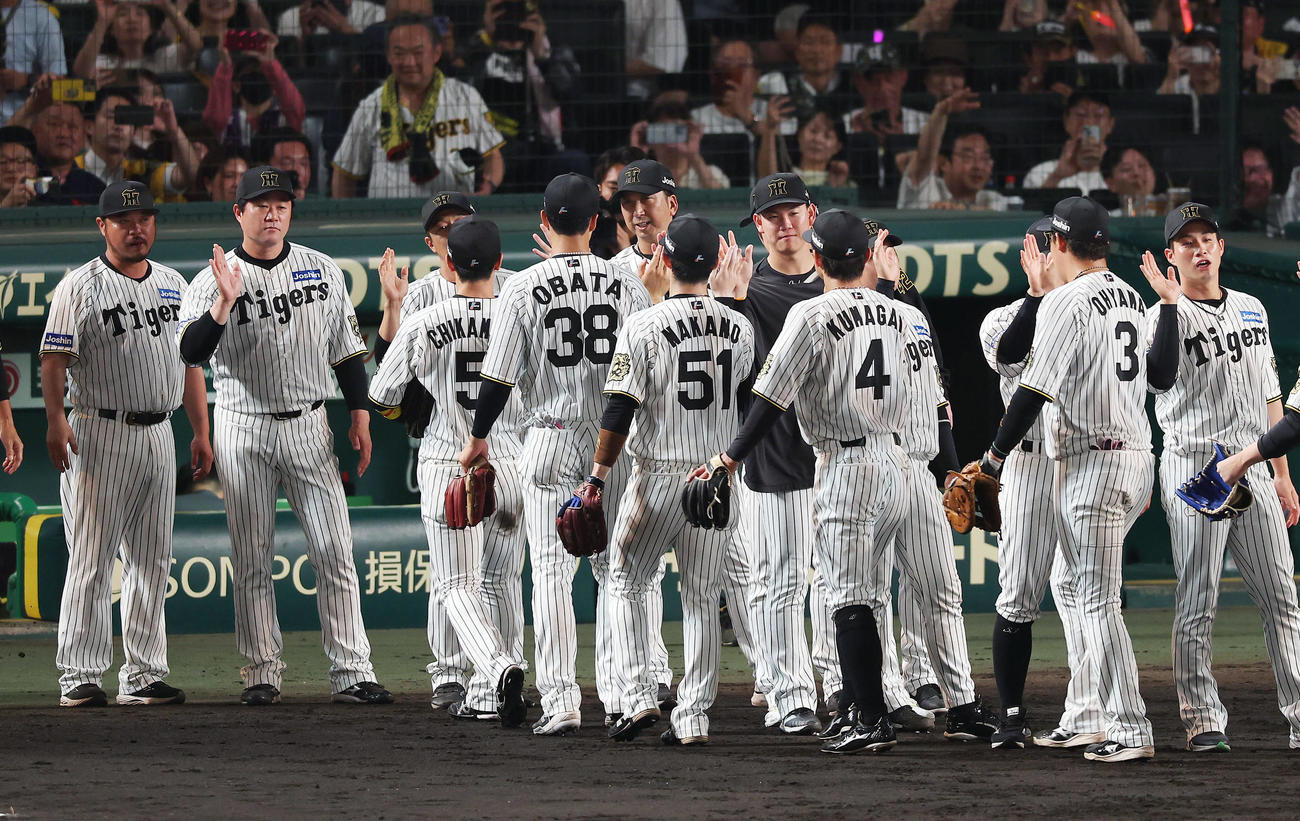 阪神対ロッテ　ロッテに勝利し連敗を止め、タッチで選手を出迎える阪神藤川監督（中央）ら（撮影・前田充）