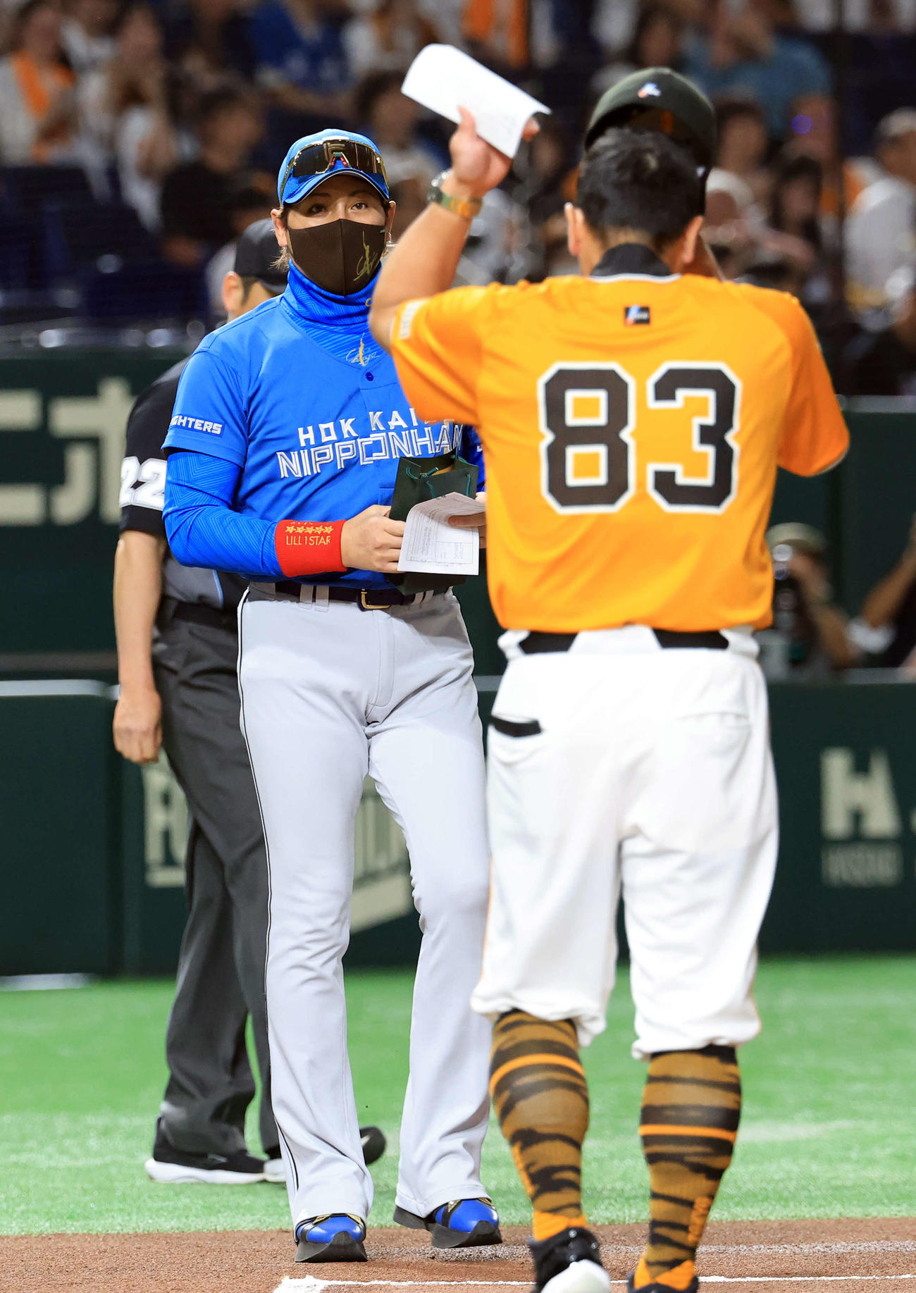 巨人対日本ハム　メンバー最終確認で、お土産を手に巨人阿部監督（手前）のもとに向かう日本ハム新庄監督（撮影・浅見桂子）