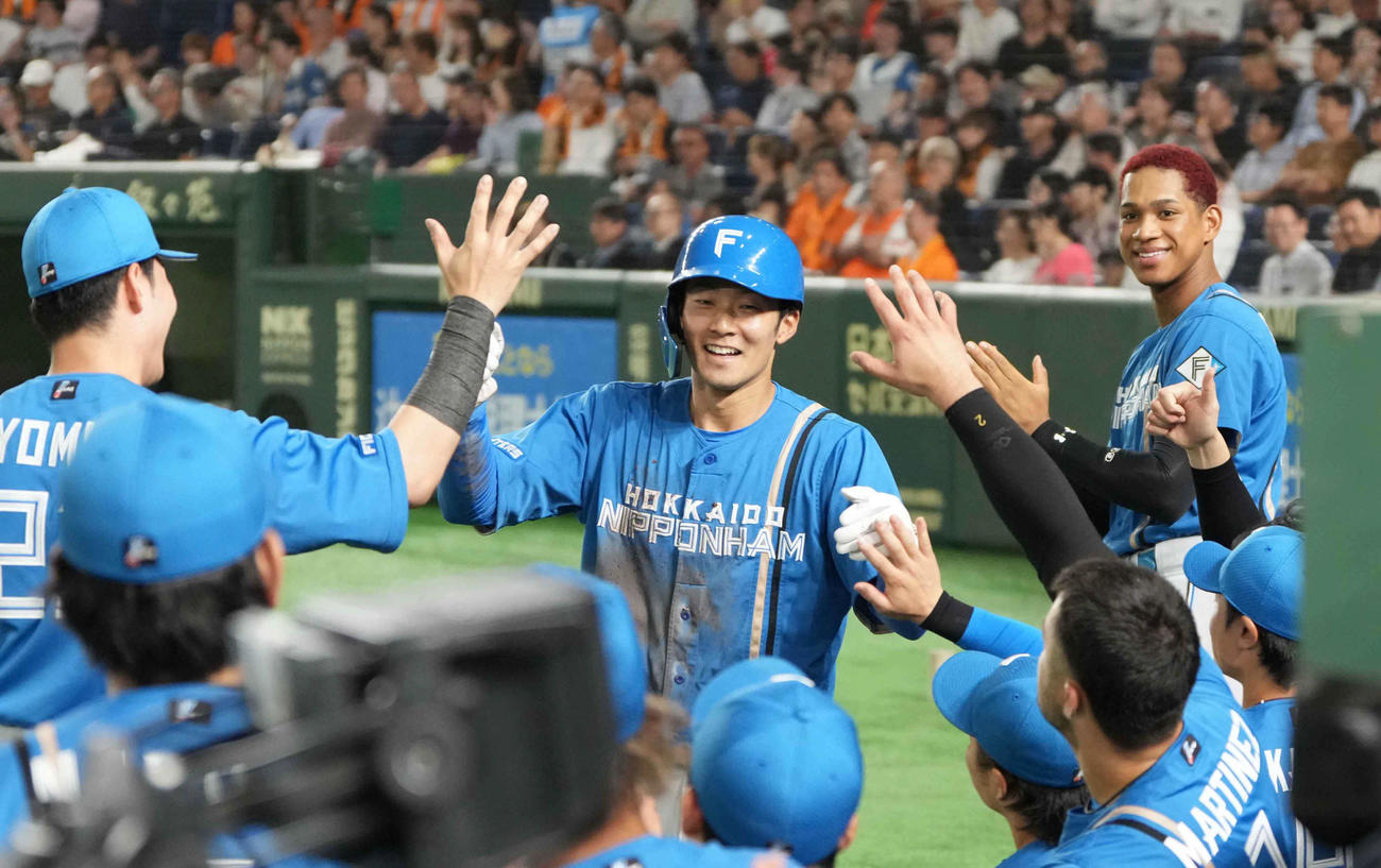 巨人対日本ハム　2回表日本ハム2死一塁、上川畑の先制右適時二塁打で生還した石井（中央）はベンチのナインの祝福を受ける（撮影・小沢裕）