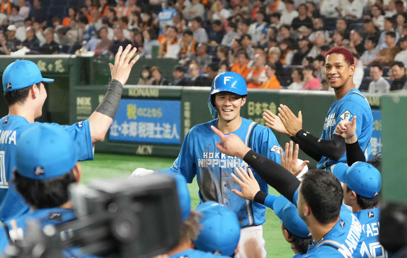巨人対日本ハム　2回表日本ハム2死一塁、上川畑の先制右適時二塁打で生還した石井（中央）はベンチのナインの祝福を受ける（撮影・小沢裕）