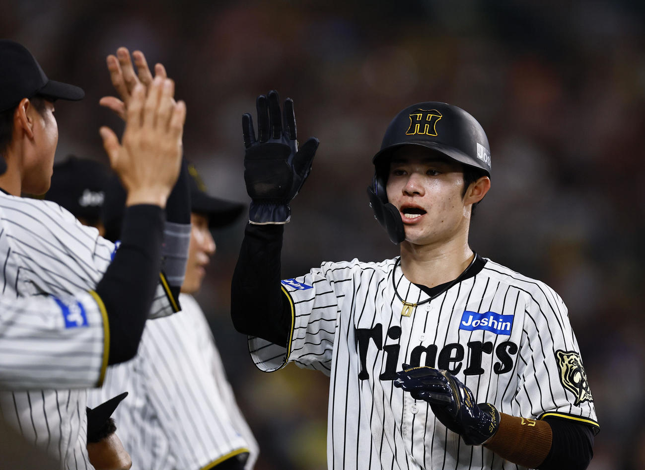 阪神対ロッテ　7回裏阪神2死一、二塁、大山の中前適時打で生還し、ナインとタッチを交わす中野（撮影・藤尾明華）