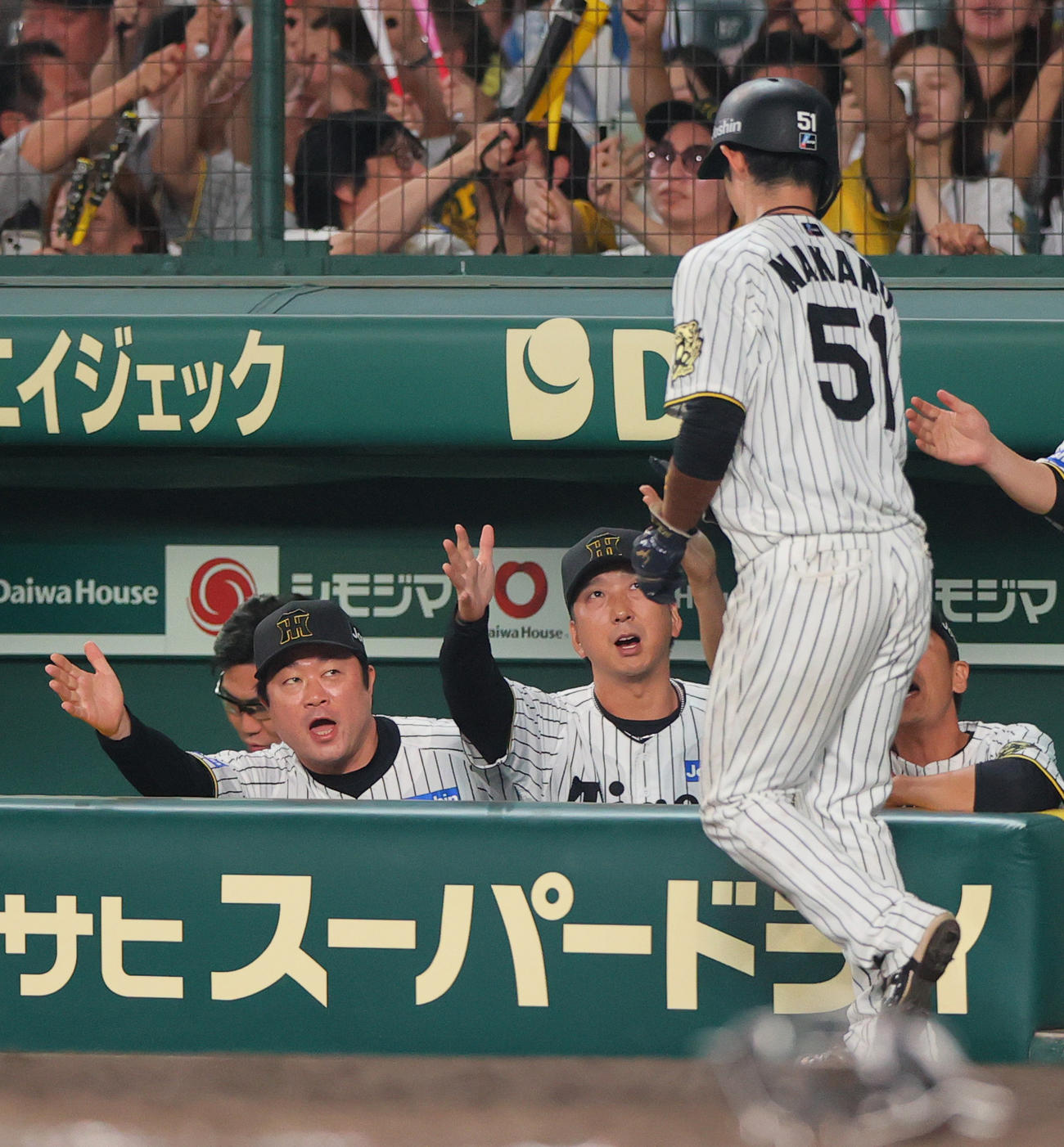 阪神対ロッテ　7回裏阪神2死一、二塁、藤川監督（左から3人目）は大山の中前適時打で生還の中野（手前）を出迎える（撮影・上山淳一）