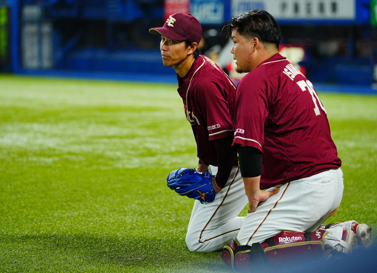 ヤクルト対楽天　イニング間に投球練習する楽天岸（左）と正座して話す石原（撮影・垰建太）