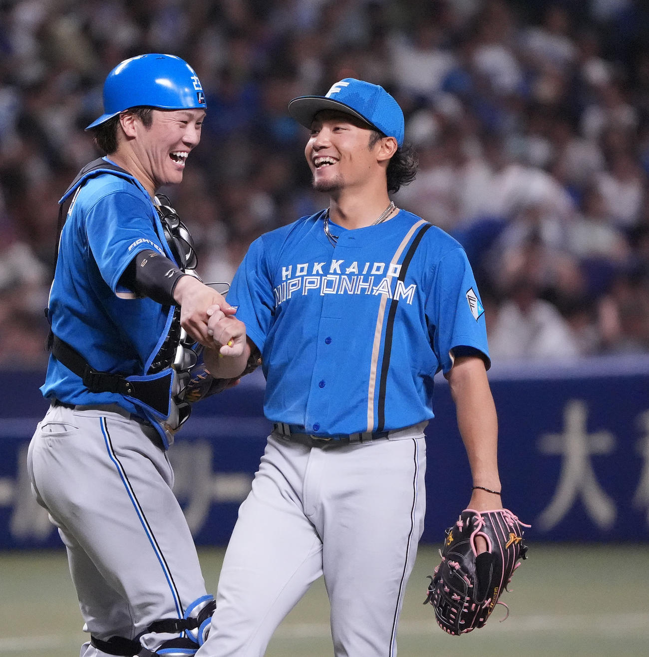 中日対日本ハム　試合終了、中日に完封勝利し伏見（左）とタッチを交わし喜ぶ伊藤（撮影・森本幸一）