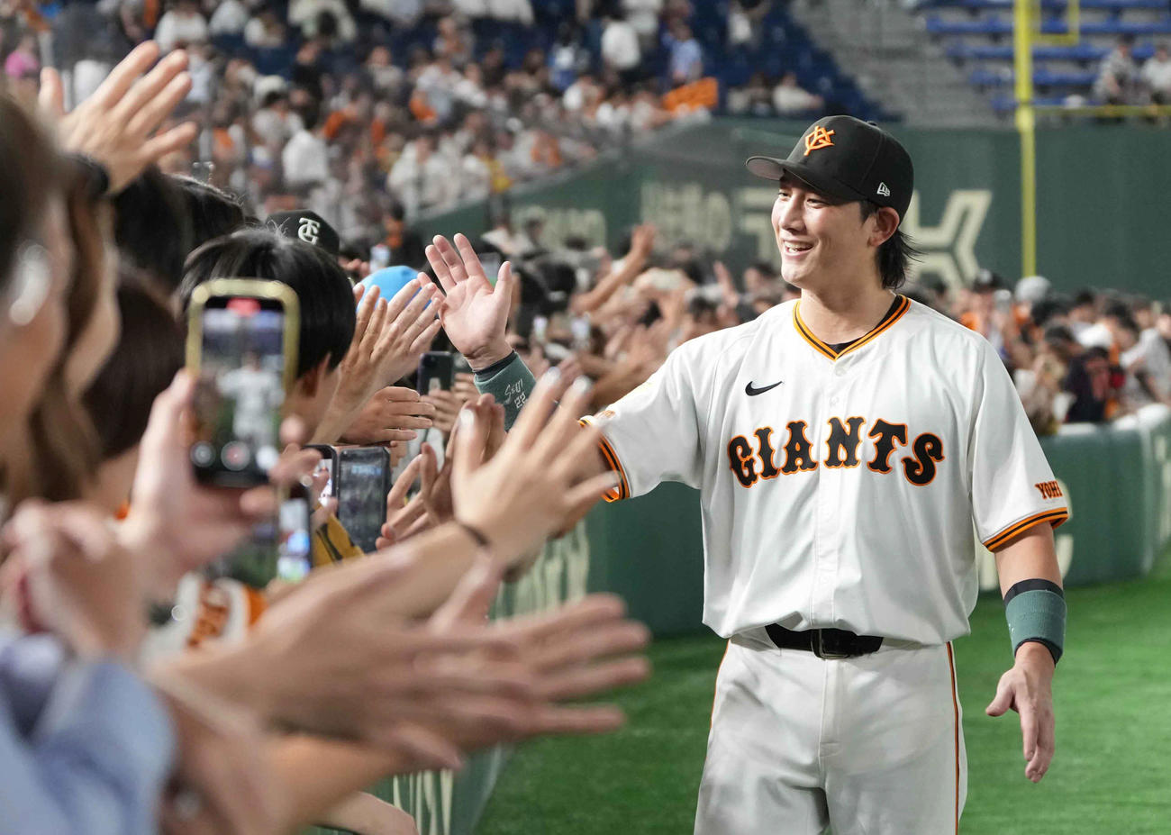 巨人対西武　今季初スタメンで勝利に貢献した巨人小林はファンとハイタッチ（撮影・小沢裕）