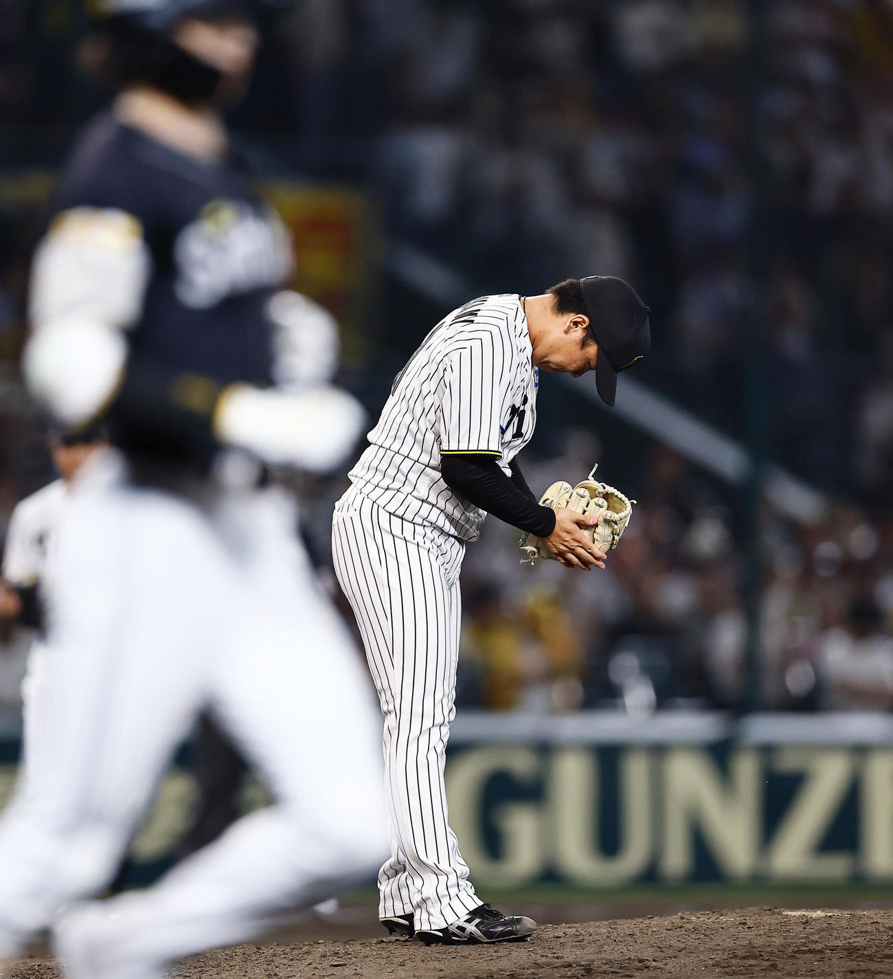 阪神対ソフトバンク　8回表ソフトバンク1死、周東を投ゴロに打ち取り、グラブをたたく村上（撮影・藤尾明華）