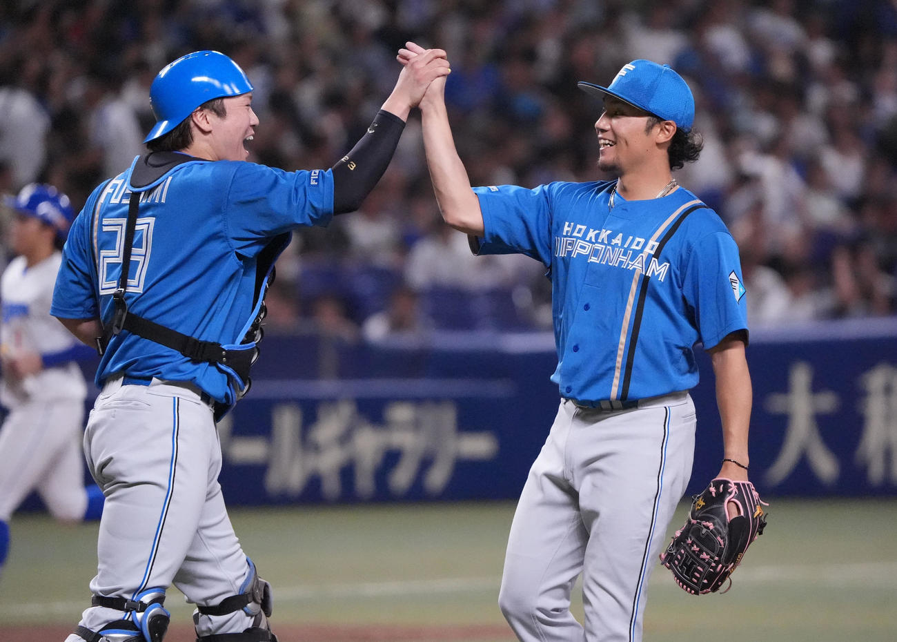 中日対日本ハム　試合終了、中日に完封勝利し伏見（左）とタッチを交わし喜ぶ伊藤（撮影・森本幸一）