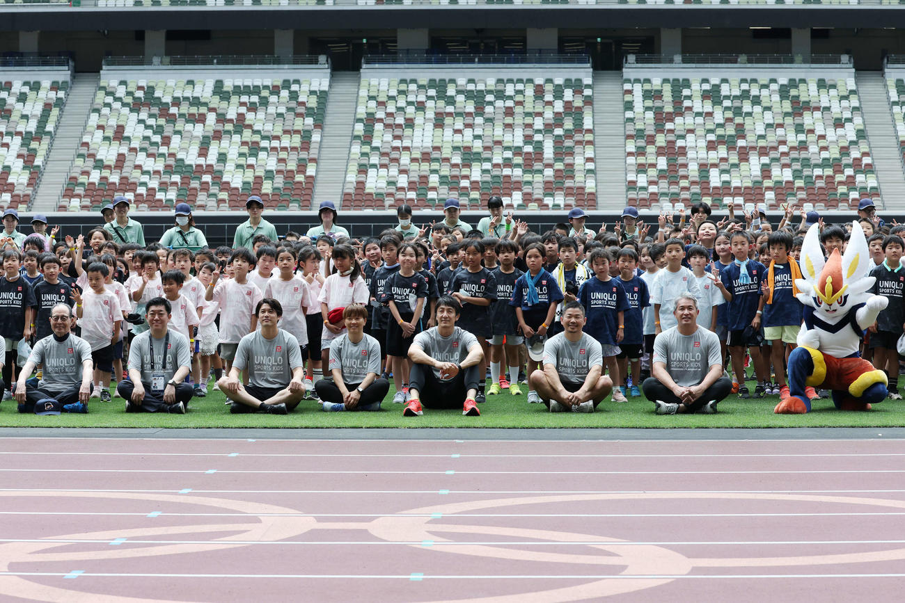 「JFAユニクロマルチスポーツキッズ」で子どもたちと記念撮影する、左から王氏、西原日本サッカー協会副会長、内田氏、宮間氏、朝原氏、田中氏、五十嵐氏、エースバーン（撮影・宮地輝）