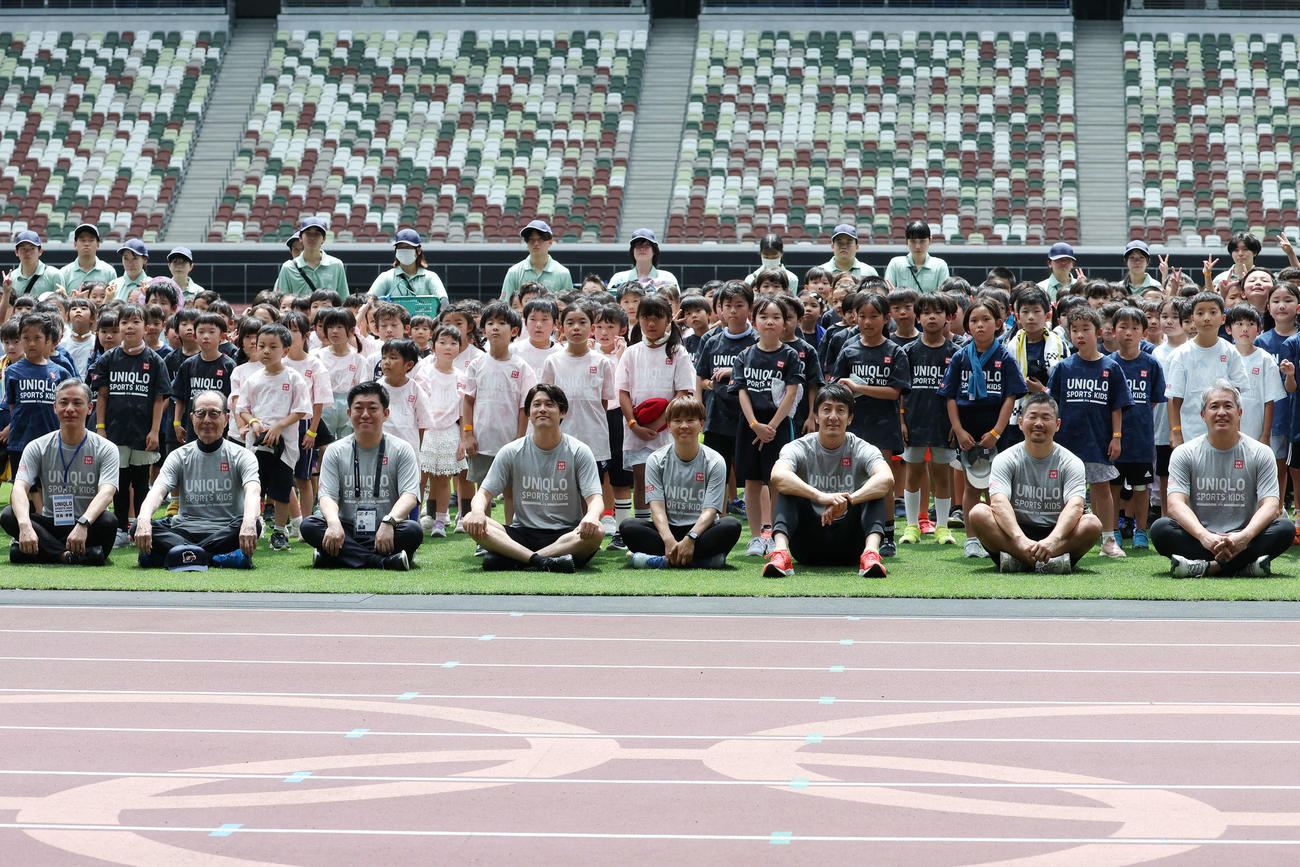 「JFAユニクロマルチスポーツキッズ」で子どもたちと記念撮影する、左から清ユニクロ日本COO、王氏、西原日本サッカー協会副会長、内田氏、宮間氏、朝原氏、田中氏、五十嵐氏（撮影・宮地輝）