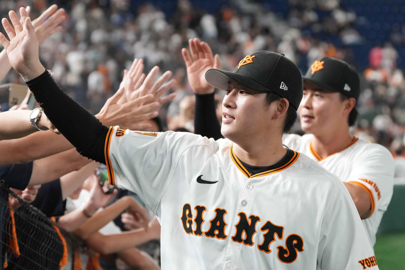 巨人対西武　ファンとハイタッチする巨人増田陸。後方は岡田（撮影・小沢裕）
