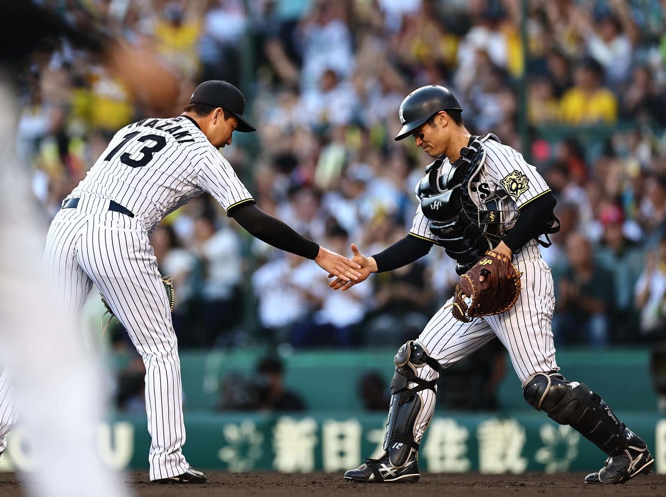 阪神対ソフトバンク　セーブをあげた岩崎（左）は坂本と握手を交わす（撮影・上田博志）