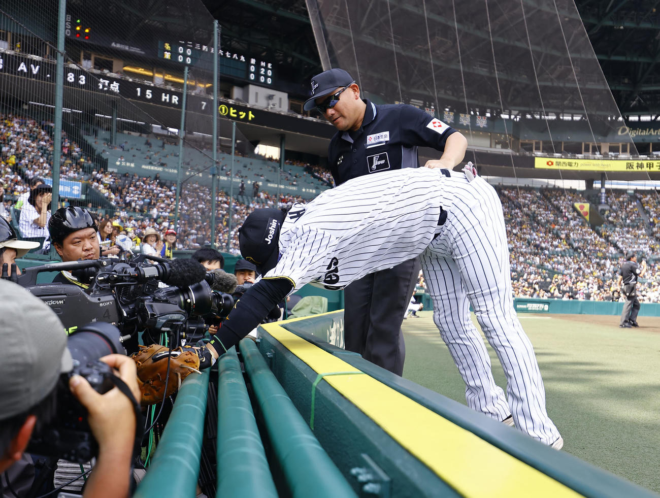 阪神対ソフトバンク　3回表ソフトバンク2死、野村の邪飛を追って、カメラ席に倒れ込み引き起こされる一塁手大山（撮影・藤尾明華）