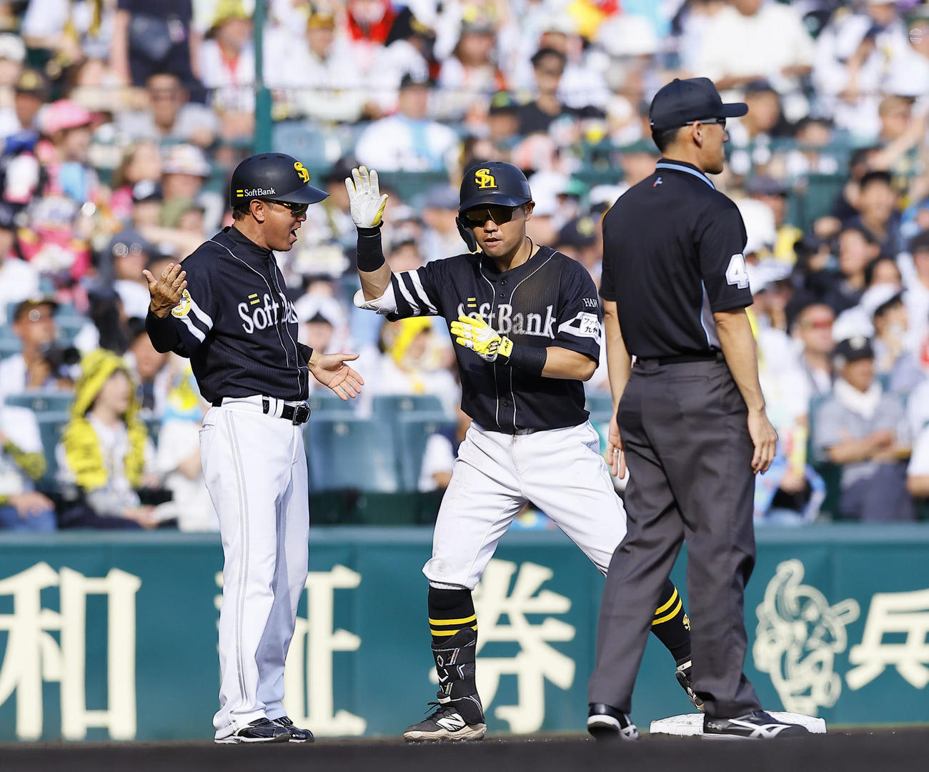 阪神対ソフトバンク　8回表ソフトバンク2死二塁、中村は左越えに適時三塁打を放ちタッチを交わす（撮影・藤尾明華）