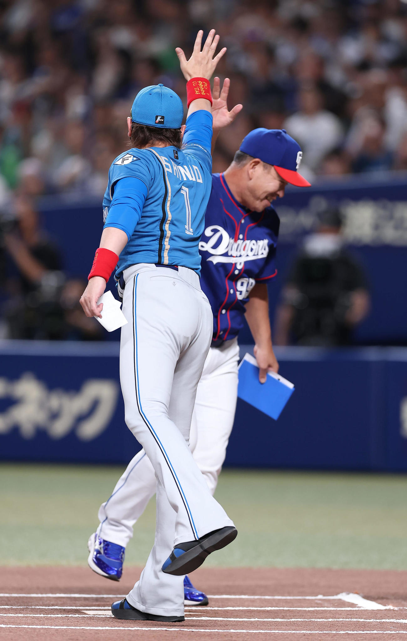 中日対日本ハム　メンバー表交換でハイタッチを交わす日本ハム新庄監督（手前）と中日井上監督（撮影・前田充）