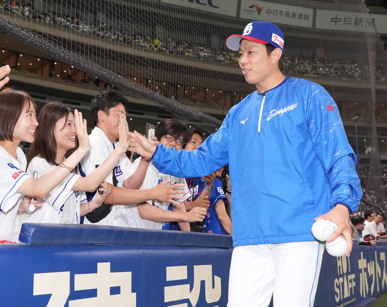 中日対日本ハム　ヒーローの松葉（右）はファンとタッチを交わす（撮影・森本幸一）