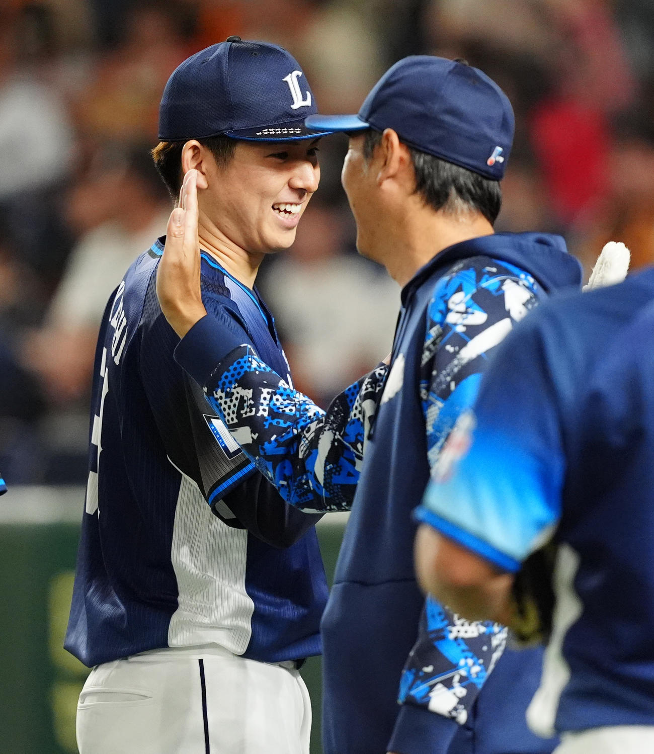 巨人対西武　勝利投手となり西武西口監督（右）とタッチを交わす武内（撮影・清水貴仁）