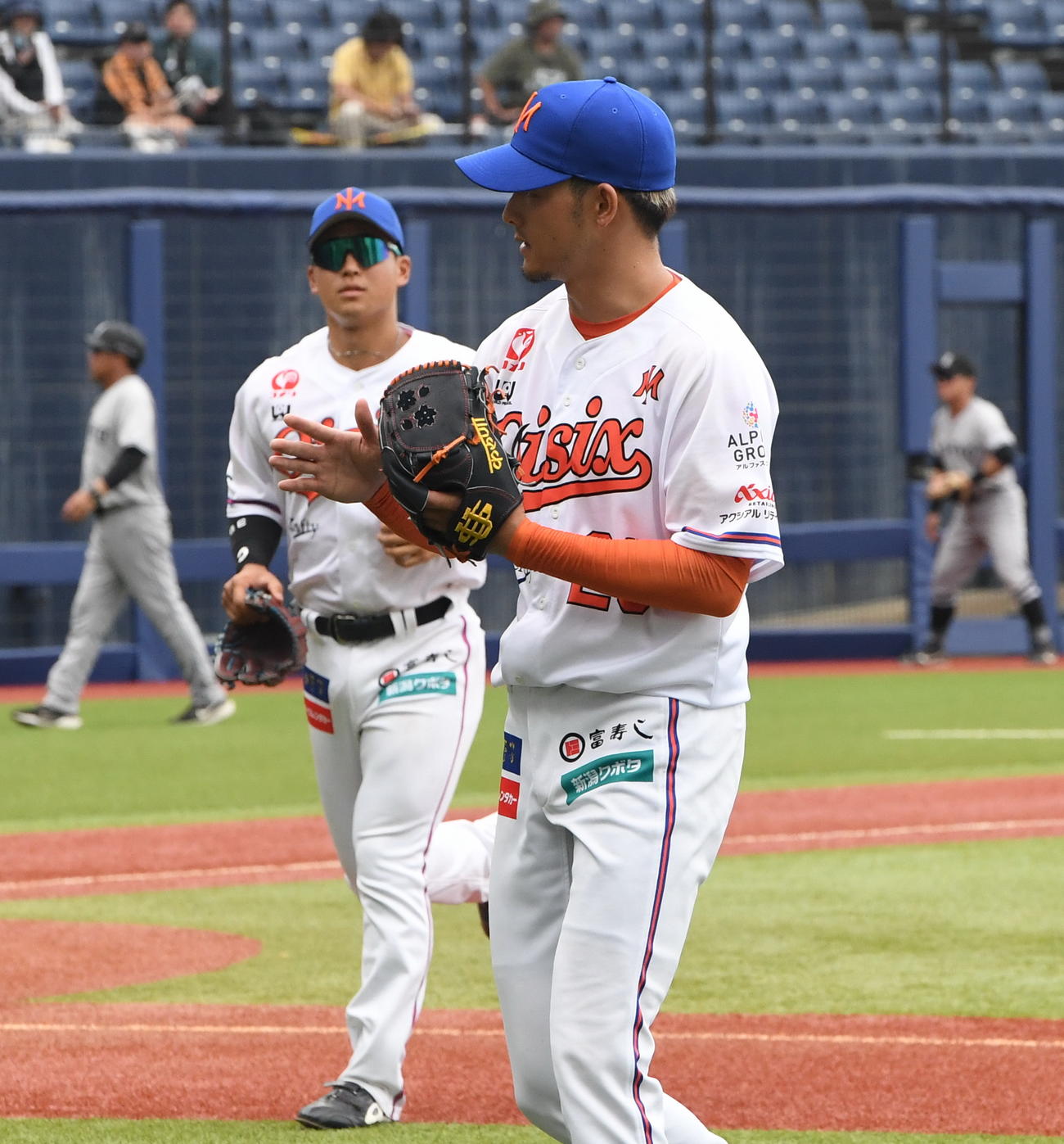 グラブをたたいてベンチに戻るオイシックス先発の藪田（右）（撮影・小林忠）