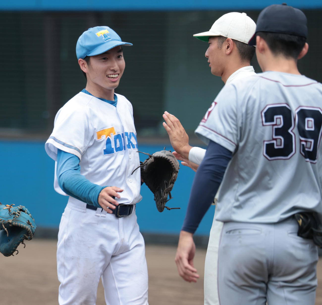 紅白戦　4回から登板した東大・渡辺（左）は無失点に抑え早大・寺尾とハイタッチする（撮影・柴田隆二）