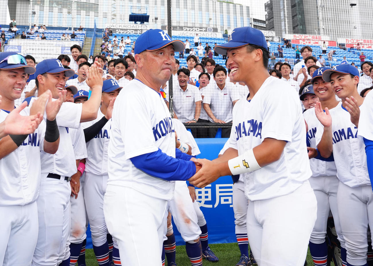 入れ替え戦で日大に連勝し、駒大主将の出村（中央右）から勝利球を受け取った香田監督（撮影・江口和貴）