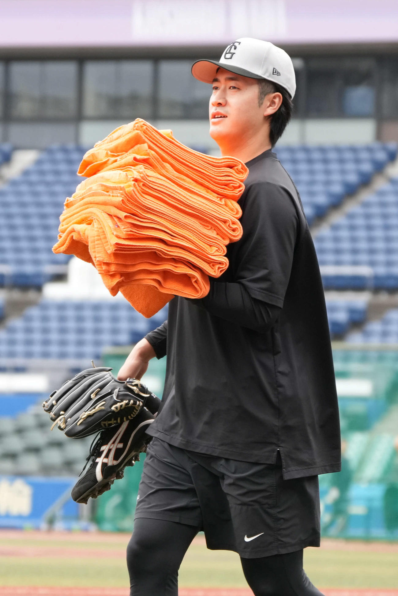 ロッテ対巨人　試合前の練習で投手陣が使うタオルを運ぶ巨人先発の西舘（撮影・小沢裕）