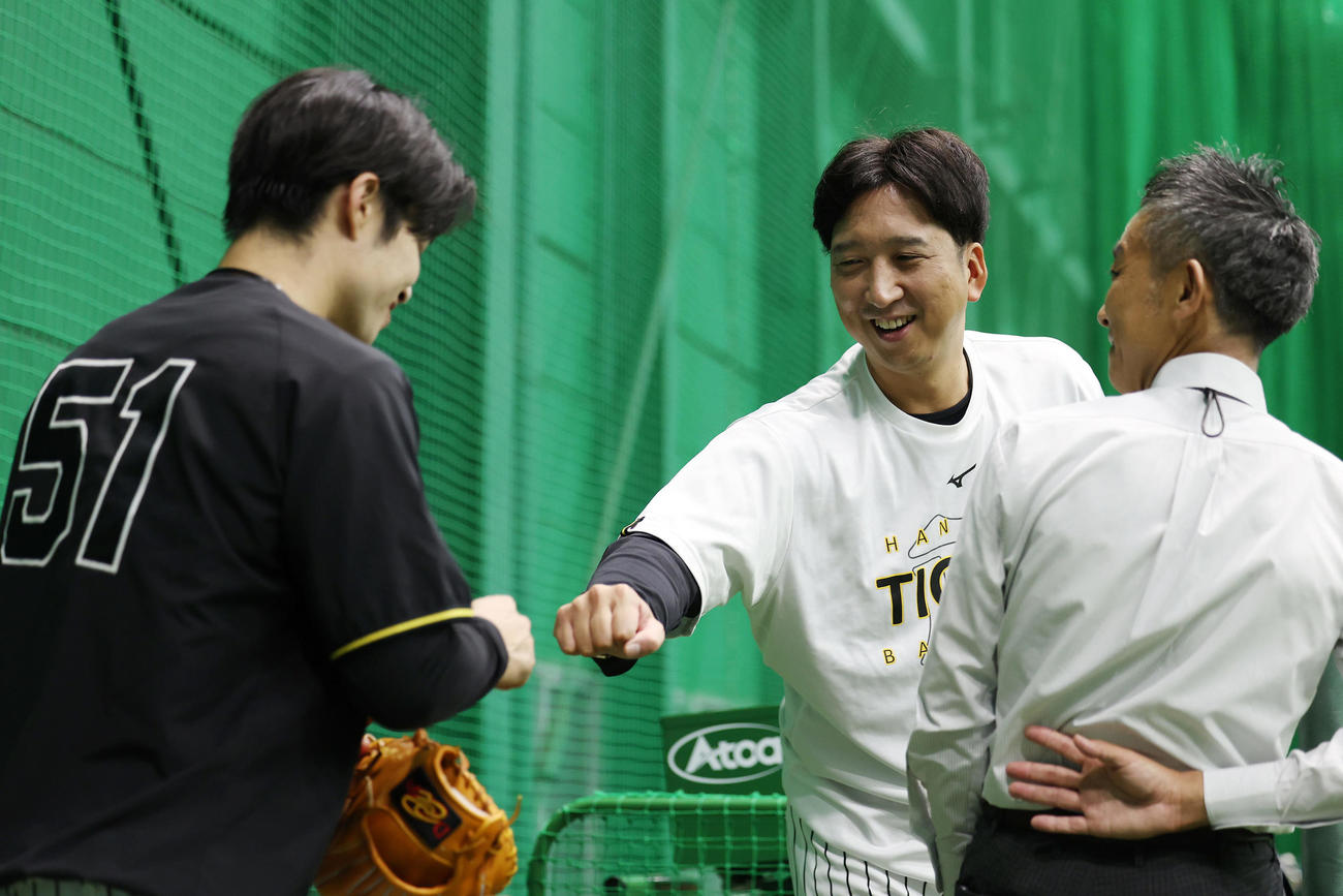 練習を終えた中野拓夢（左）とグータッチを交わす阪神藤川球児監督（撮影・前田充）