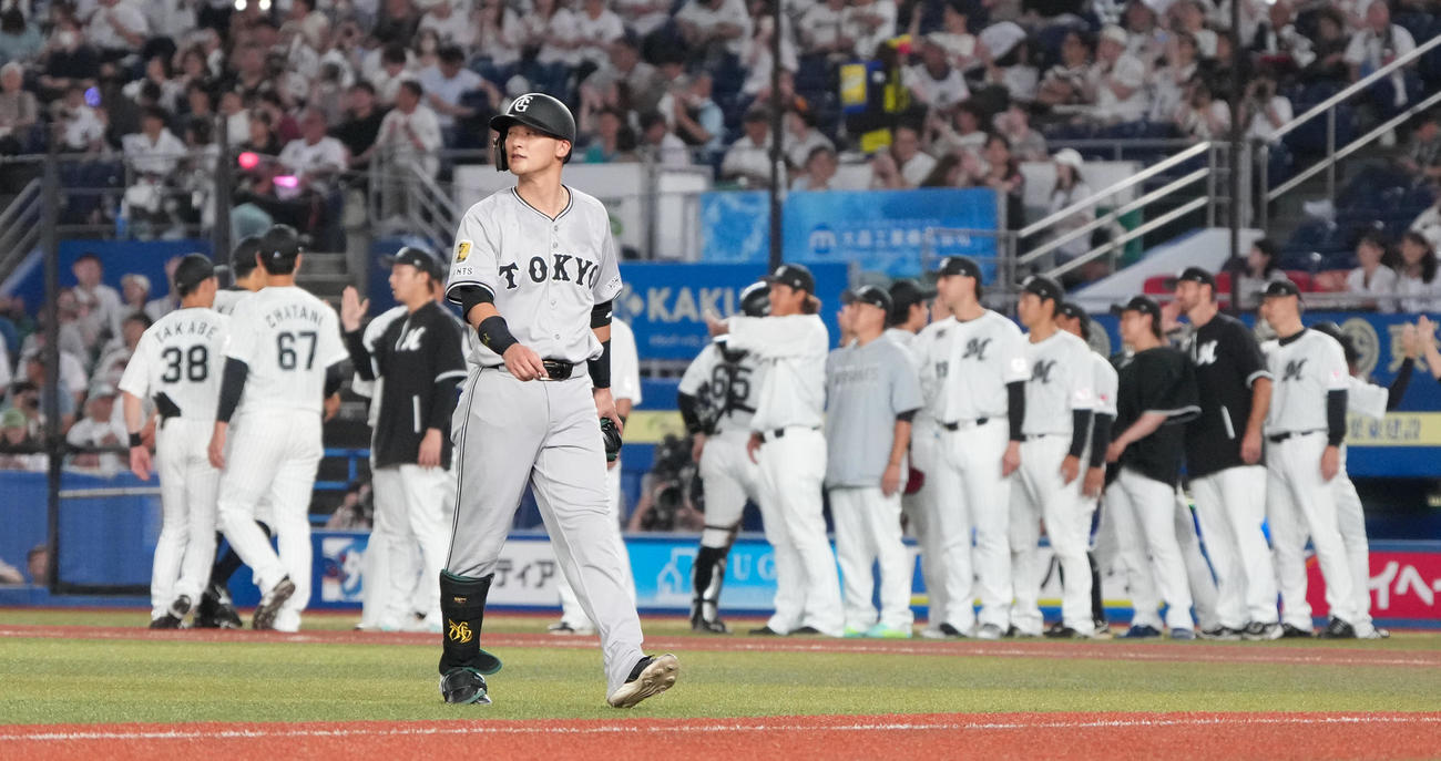 ロッテ対巨人　最後の打者となり勝利に沸くロッテナインを背にベンチへ引き揚げる巨人吉川（撮影・小沢裕）