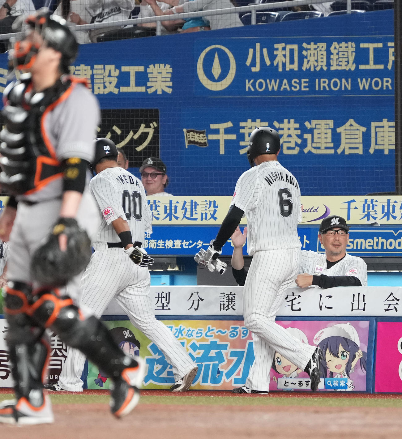 ロッテ対巨人　6回裏ロッテ2死二、三塁、岡の2点左適時二塁打で生還した、左から池田、西川を祝福する吉井監督（撮影・小沢裕）