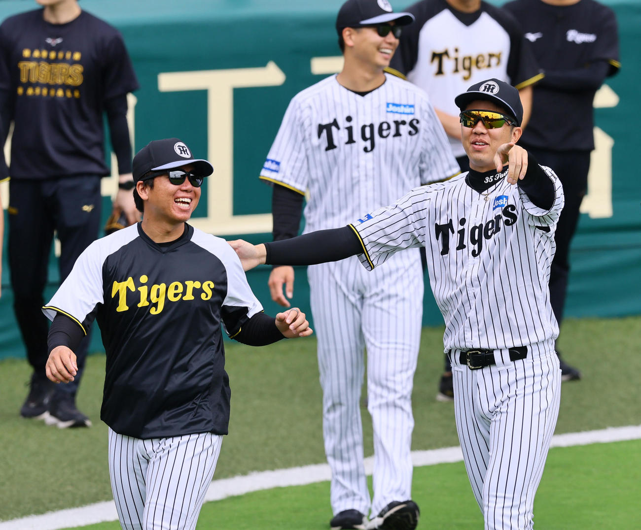 カメラに向かって誕生日の村上（左）を誘導する阪神才木（撮影・藤尾明華）