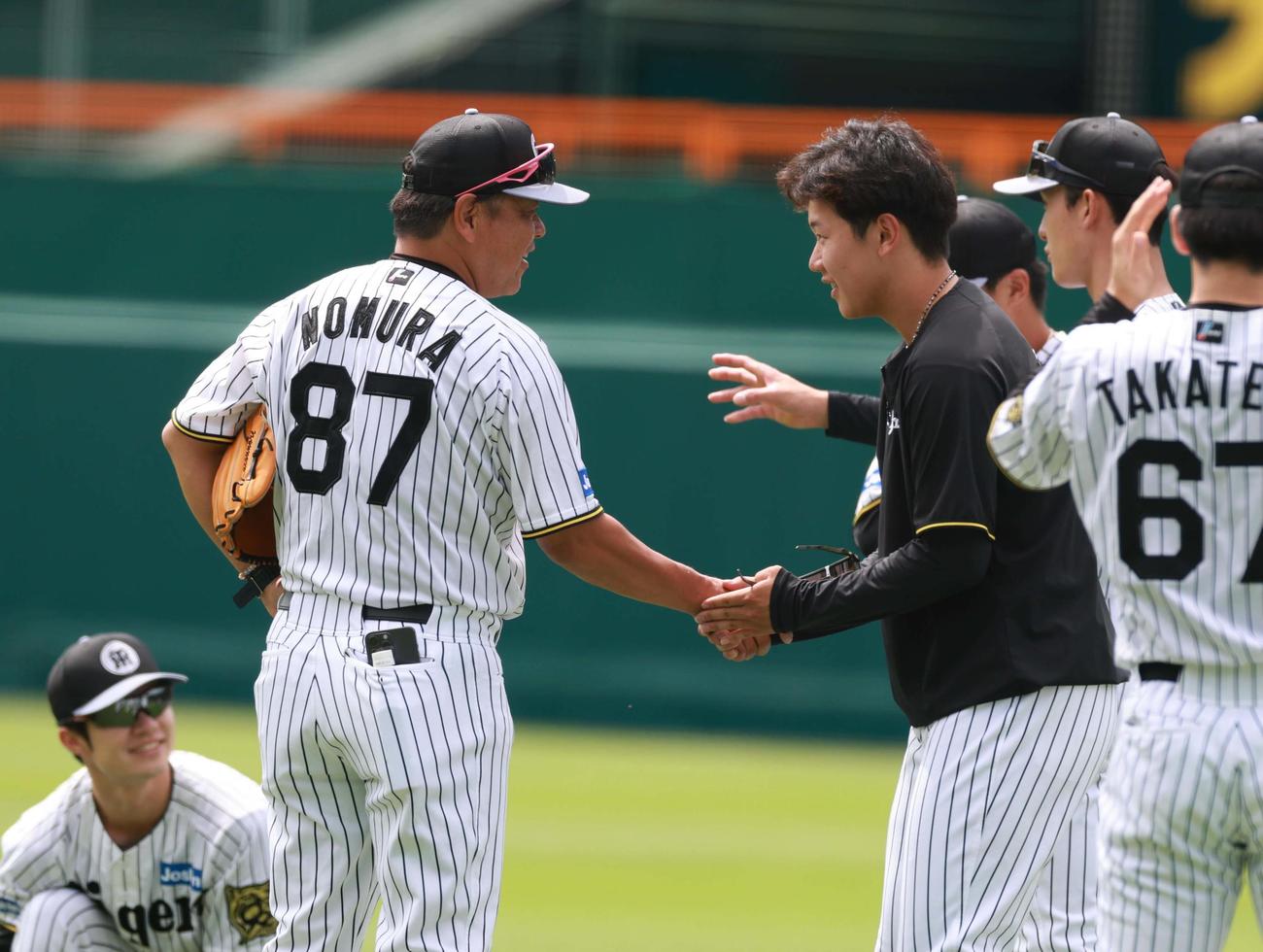 1軍に合流した門別（右）は野村コーチと握手を交わす（撮影・上田博志）