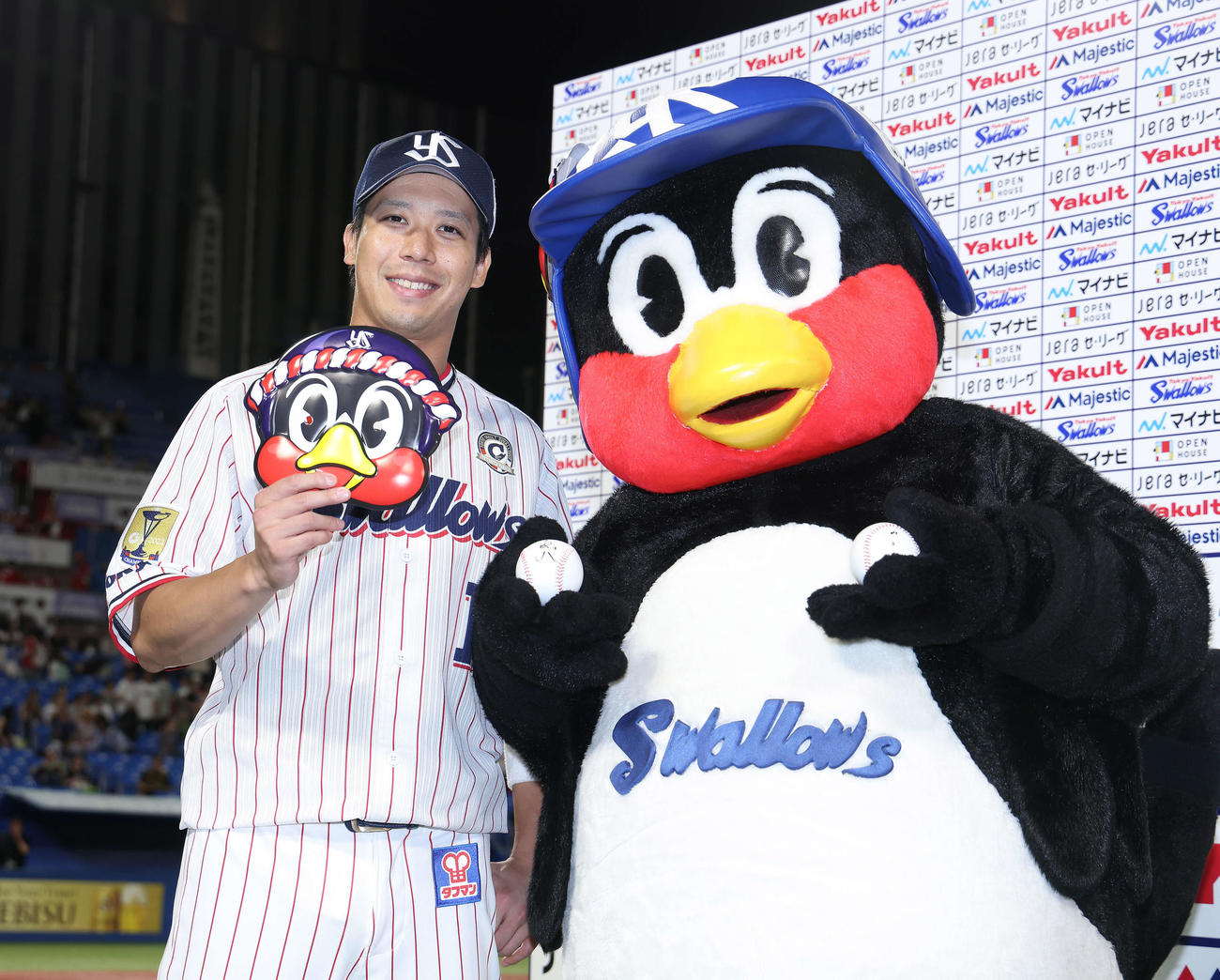 ヒーローインタビュー後につば九郎の面を手に笑顔で写真に納まるヤクルト山田（2023年8月8日撮影）