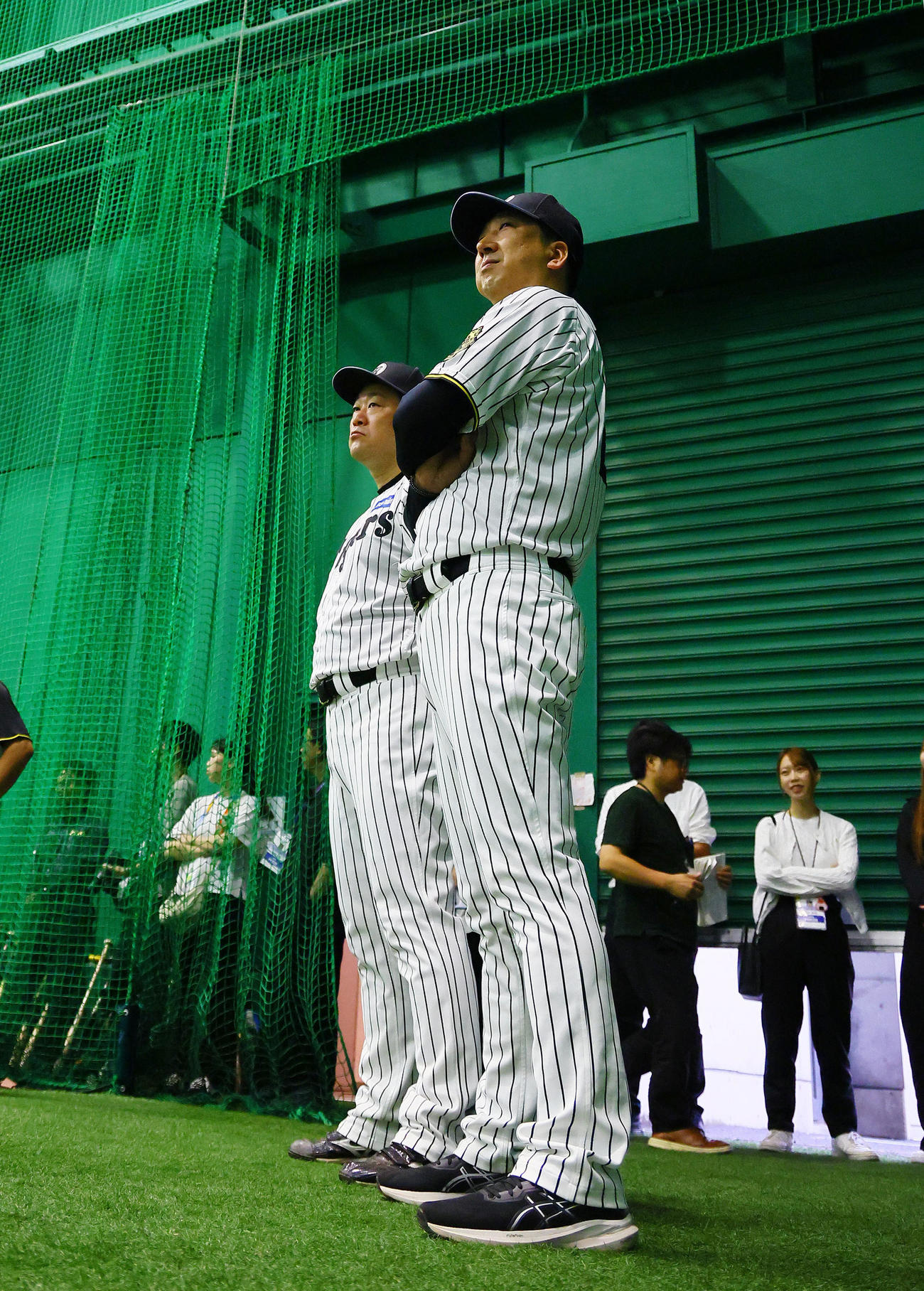 練習を見つめる阪神藤川監督（右）と安藤投手チーフコーチ（撮影・藤尾明華）