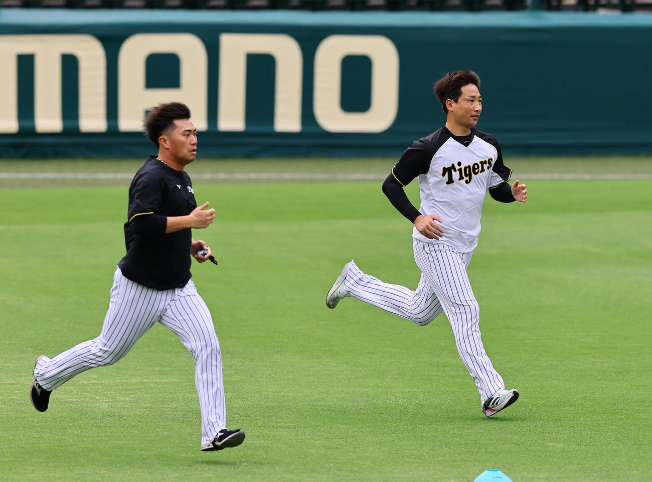 ダッシュする阪神岩崎（右）と桐敷（撮影・藤尾明華）