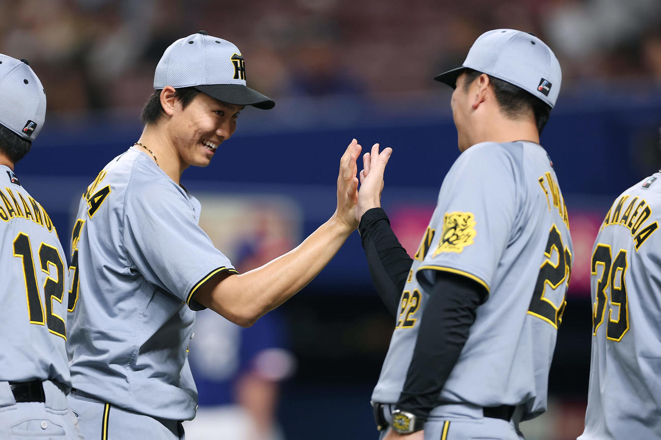 中日対阪神　中日に勝利し、タッチを交わす阪神湯浅（左）と藤川監督（撮影・前田充）