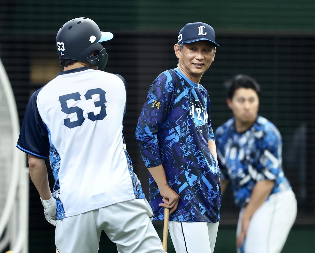 西武対日本ハム　試合前、牧野（左）と言葉を交わす西武西口監督（撮影・河田真司）